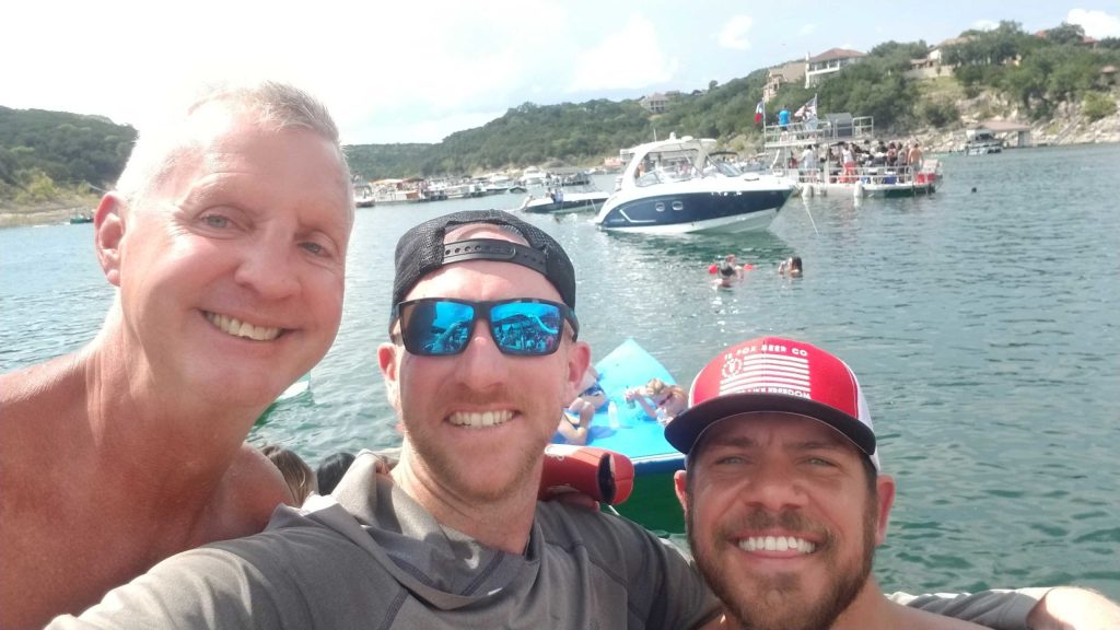 a man smiling next to a body of water
