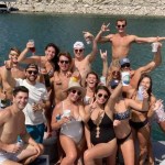 a group of people posing in front of a body of water