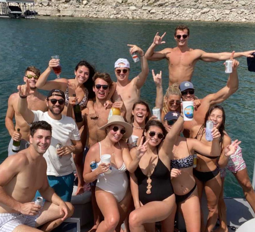 a group of people posing in front of a body of water