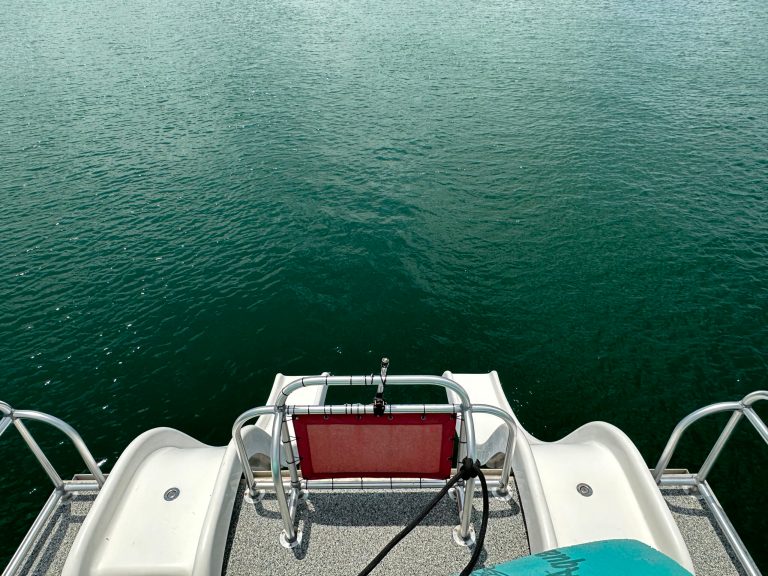 a boat that is sitting on a chair next to a body of water