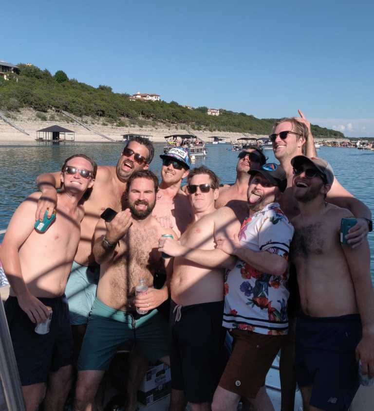 a group of people posing in front of a body of water