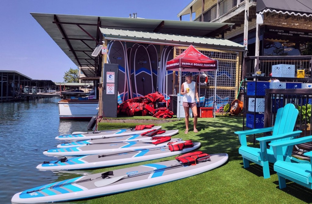 a group of people sitting at a table with a blue umbrella